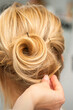 © okskukuruza - Close up of female hairdresser styling blonde hair of a young woman in a beauty salon
