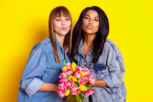 Photo Of Adorable Ladies Closed Eyes Kiss Lips Arms Hold Fresh Flowers Isolated On Yellow Color Background
