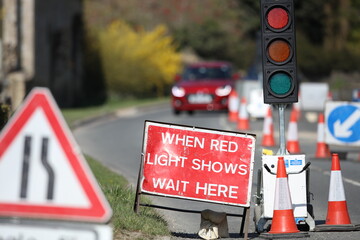 Country lane road work temporary traffic lights and signs