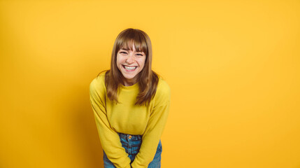 Portrait of happy young woman smiling at camera isolated on bright yellow background