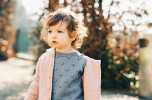 Outdoor Portrait Of Adorable Toddler Girl Of 1 -1,5 Year Old Wearing Blue Pullover And Pink Jacket, Cold Weather