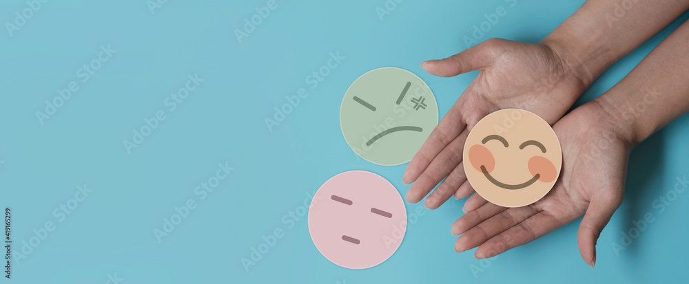 Hand holding paper cut happy smile face on blue background, positive thinking, mental health assessment , world mental health day concept	 - obrazy, fototapety, plakaty 