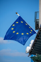 Europe or European Union flag waving, blown by an angel on the roofs of houses, vertical