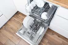 Open Dishwasher With Clean Utensils In It