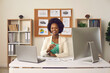 © Studio Romantic - Happy young black woman looking at camera sitting at office table with laptop and desktop computer. Portrait of smiling businesswoman, head of company, business firm owner or economics teacher at work