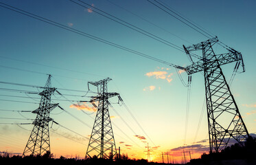 Wall Mural - silhouette of high voltage power lines against a colorful sky at sunrise.