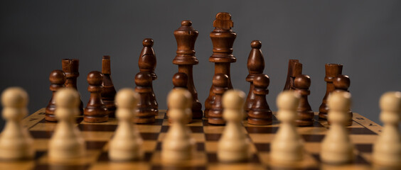 Wall Mural - Blurred white pawns against group of black chess figures on chessboard