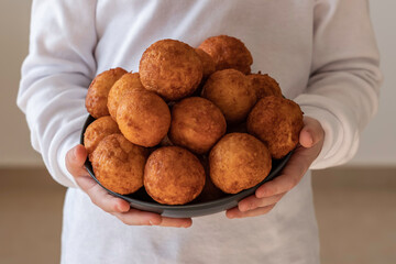 Canvas Print - Child holding a plate of Cottage Cheese Donuts.