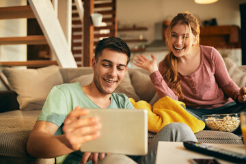 Wall Mural - Happy couple having video call over touchpad at home.