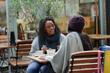 © Paul Bradbury/Caia Image - Mother and daughter talking and enjoying lunch at cafe patio table