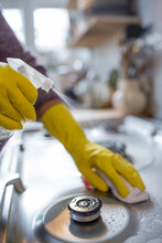 Close Up Woman In Rubber Gloves Spray Cleaning Stovetop