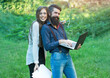 © Volodymyr - Business couple of woman and man with devices of laptop glasses mobile phone paper folder and standing outdoor on green grass.