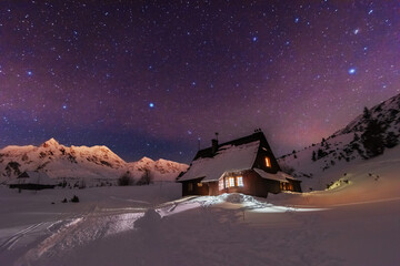 Wall Mural - night winter landscapes in the high tatras, with mountain houses on a background of snow-capped moun