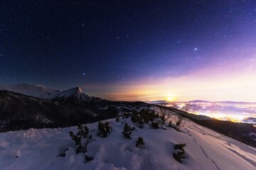 Wall Mural - night winter landscapes in the high tatras, with mountain houses on a background of snow-capped moun