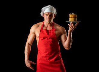 Pancakes on breakfast. Sexy chef baker in apron. Bakery man.