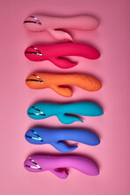 Flat Lay Colourful Silicone G-spot Vibrator Dildos For Women On Pink Background, Many Dildos In Row, Just For Pleasure And Fun. Private Intimate Life. Sex Concept