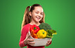 Happy kid with basket of fresh vegetables