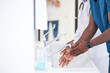 © Roman - Cropped african Doctor Man washing hands properly with soap to be protected for Coronavirus 2019-nCoV during work in hospital. Medical Cleanup