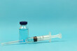 © Nikolay - Medical concept - syringe and medical injection vial on blue background