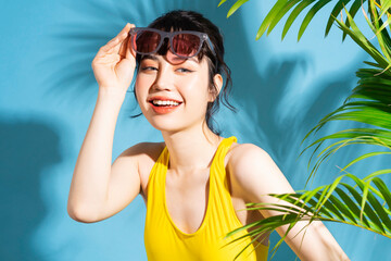 Wall Mural - Beautiful Asian woman wearing yellow jumpsuit on blue background and, summer concept