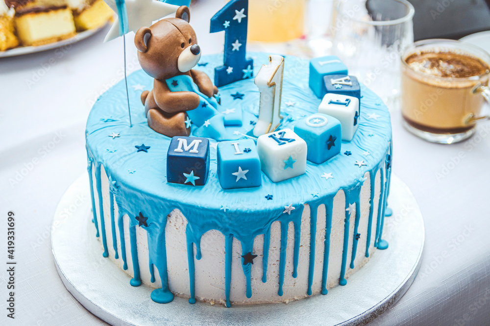 Obraz na płótnie Niebieski tort czekoladowy ze zdobieniem w postaci misia z okazji pierwszych urodzin Mikołaja. w salonie