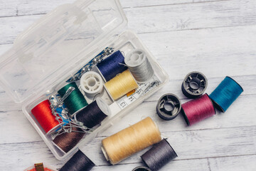 sewing thread and needles on a wooden table top view