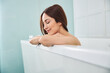 canvas print picture - Joyful spa client sitting in a white bath