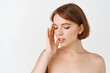 © Cookie Studio - Skin care beauty. Sensual young woman, naked shoulders, look aside and show natural beautiful face without make-up, nourish and apply skin care products for hydrated and detoxifying effect