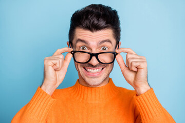 Sticker - Photo of young excited man happy positive smile surprised news hands touch glasses isolated over blue color background