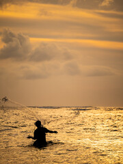 Wall Mural - Fisherman on the beach at sunset in Bali
