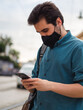 © David Martínez - Hombre joven usando su movil con mascarilla