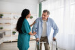 © Prostock-studio - Young nurse helping older man to walk with frame at retirement home. Professional eldercare service