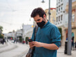 © David Martínez - Hombre joven usando su movil con mascarilla