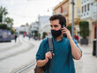 © David Martínez - Hombre joven usando su movil con mascarilla