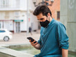 © David Martínez - Hombre joven usando su movil con mascarilla