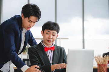 Wall Mural - Group of young business people sit at their desks with smiling colleagues together in the office.  Meeting business people  planning concept, laptop meeting ideas. Concentrate on work. LGBT teamwork.