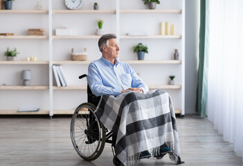 Wall Mural - Sad disabled senior man sitting on wheelchair alone at retirement home, looking through window