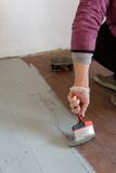 Fototapeta  - Malowanie starej podłogi z desek na kolor jasnoszary.