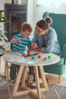 © perfectlab - Mother or art therapist and child paint watercolor together at h