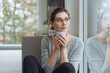 © contrastwerkstatt - Serious young woman sitting daydreaming with mug of coffee