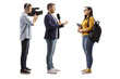 Full length profile shot of a reporter interviewing a female student and cameraman recording