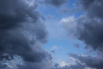 Wall Mural - Blue sky behind dark storm clouds background texture, thunderstorm