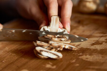 Woman Cutting Mushrooms On Wooden Board, Close-up