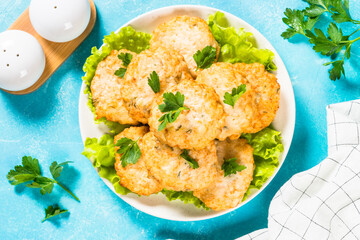 Wall Mural - Chicken cutlet in white plate served at blue stone kitchen table. Top view with copy space.