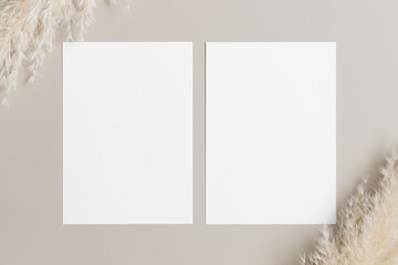 Canvas Print - Two white invitation cards mockup with a pampas decoration on the beige table. 5x7 ratio, similar to A6, A5.