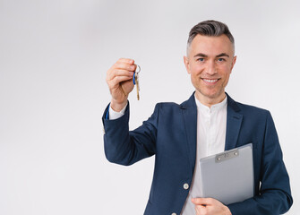 Cheerful mature caucasian estate agent holding a key of a new flat isolated over white background