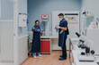 © Alberto Ortega/ADDICTIVE STOCK - Unrecognizable young male vet in sterile mask and gloves standing near female colleague while preparing for work in lab