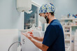 © Alberto Ortega/ADDICTIVE STOCK - Side view of unrecognizable male doctor in respiratory mask and uniform disinfecting hands in hospital
