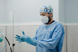 © Alberto Ortega/ADDICTIVE STOCK - Anonymous young male veterinarian in sterile uniform putting on elastic gloves while preparing for surgery in operating room
