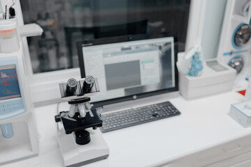 From above of microscope near computer with open program on screen in vet laboratory